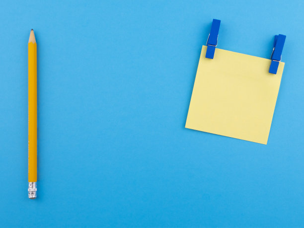 木制黄色铅笔孤立在蓝色纹理纸上，与黄色方块结合。极简模板与复制空间的俯视图概念图片下载