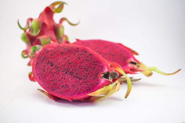 奇异的粉红色火龙果或火龙果。红色的火龙果，在白色的背景上切成两半图片下载