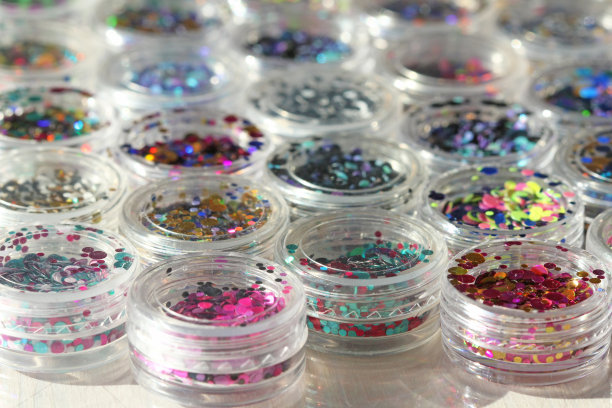 多色亮片设计的钉子在一个罐子。在jar闪闪发光。指甲用锡箔。组照片。闪闪美丽，闪闪发光。明亮的背景闪光。俯视图图片下载