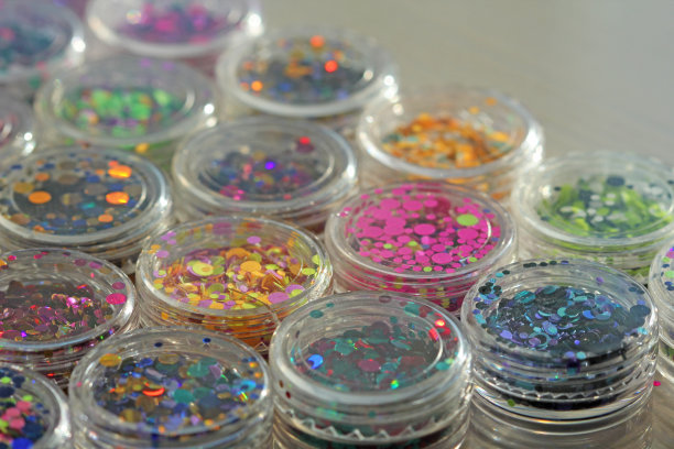 多色亮片设计的钉子在一个罐子。在jar闪闪发光。指甲用锡箔。组照片。闪闪美丽，闪闪发光。明亮的背景闪光。俯视图图片下载