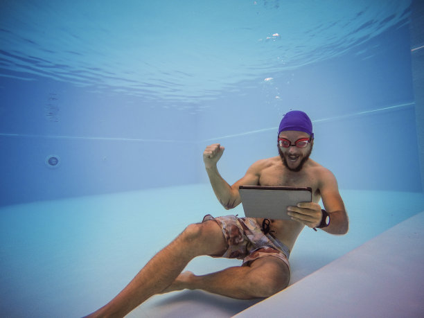 工作狂在游泳池里用平板电脑图片下载