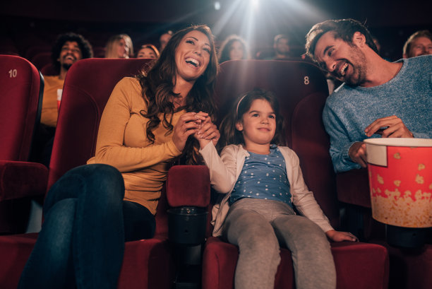年轻女孩在电影院与父母图片下载