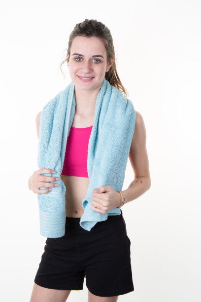 开朗自信的年轻女子与毛巾后，健身房肖像图片下载