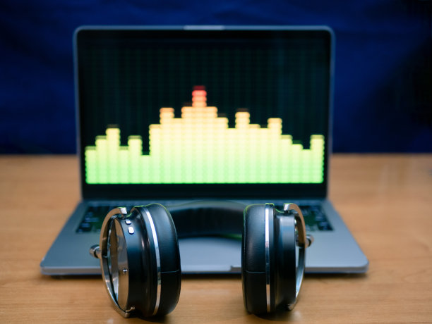 带均衡器的专业耳机放在笔记本电脑上图片下载