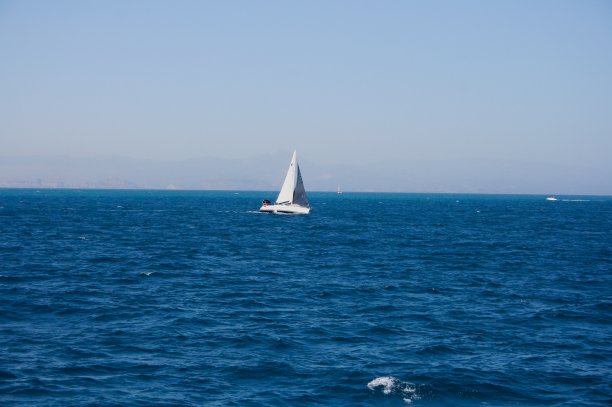 蓝色海面上美丽的白色小船图片下载