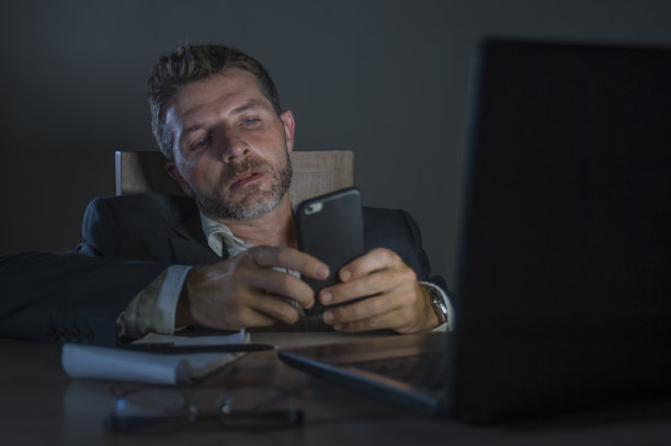 年轻的有吸引力的浪费和疲倦的企业家在办公室笔记本电脑桌工作到深夜疲惫和困倦的金融业务问题和过度工作的员工概念图片下载