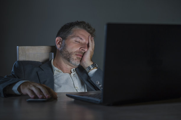 年轻的有吸引力的浪费和疲倦的企业家在办公室笔记本电脑桌工作到深夜疲惫和困倦的金融业务问题和过度工作的员工概念图片下载