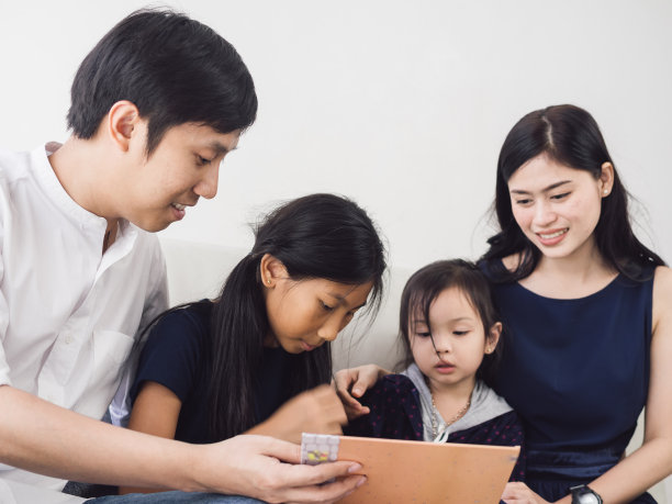 幸福亚洲家庭一起在家看书，生活理念。图片下载