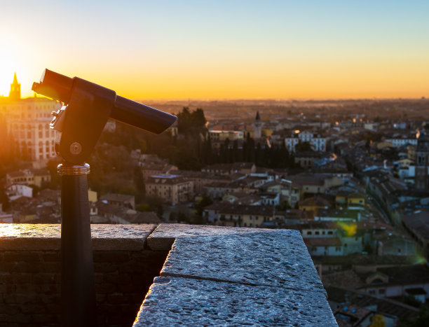 这是一张在山顶上的公共单眼望远镜的特写照片，上面有古老城市壮观的鸟瞰图图片下载