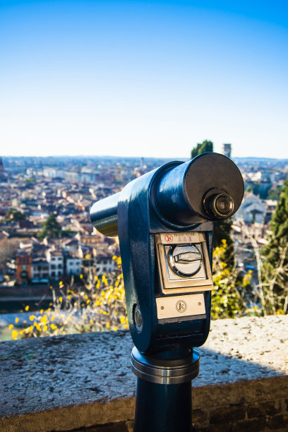 这是一张在山顶上的公共单眼望远镜的特写照片，上面有古老城市壮观的鸟瞰图图片下载