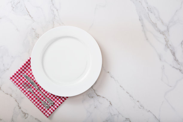 大理石厨房台面上的白色盘子。图片下载