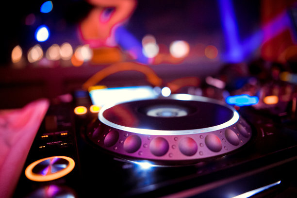 夜店里戴着耳机和混音器的俱乐部DJ图片下载