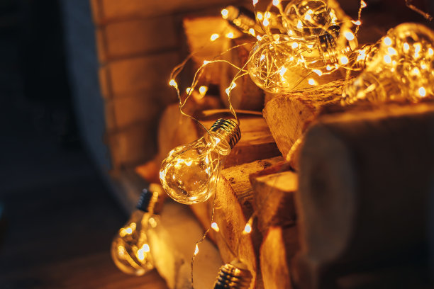 装饰gerland圣诞灯泡躺在壁炉上木制的柴火阁楼设计图片下载