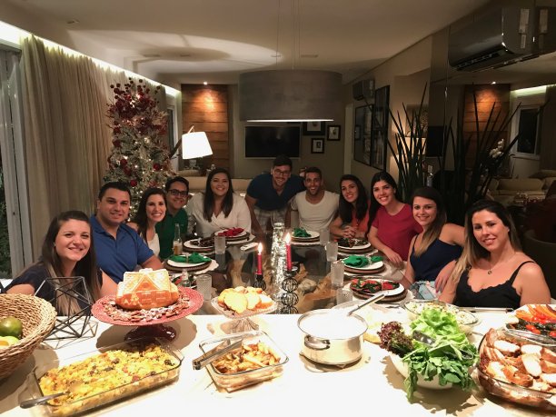 朋友们聚在一起享受圣诞晚餐-照片从手机图片下载