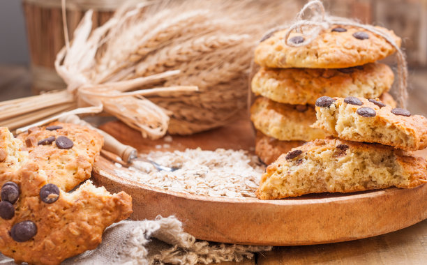 自制的燕麦蛋糕当早餐。木盘上放着巧克力饼干和一束麦穗。文本的空闲空间。复古的照片。图片下载