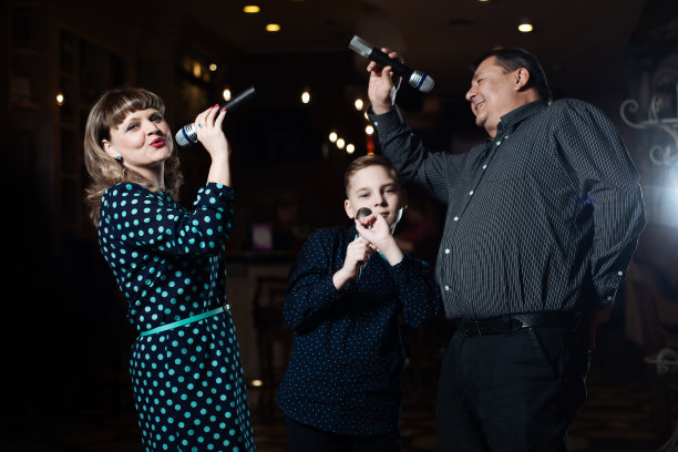 家庭卡拉ok。一个幸福的家庭，在麦克风里唱歌图片下载
