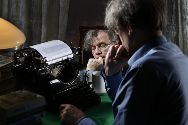 作家写了一本书。作者的形象。创造性的过程。作家在打字机上写一本书。图片下载