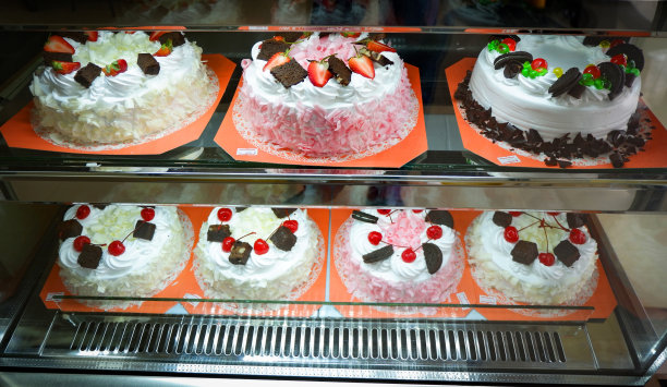 不同类型的蛋糕在陈列柜托盘蛋糕在玻璃展示在商店面包店糕点店图片下载
