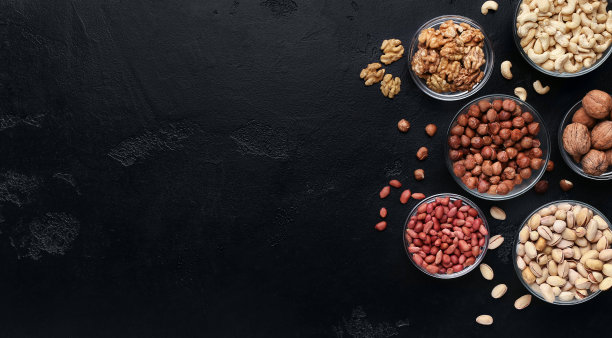 各种坚果在玻璃碗在黑色的背景图片下载