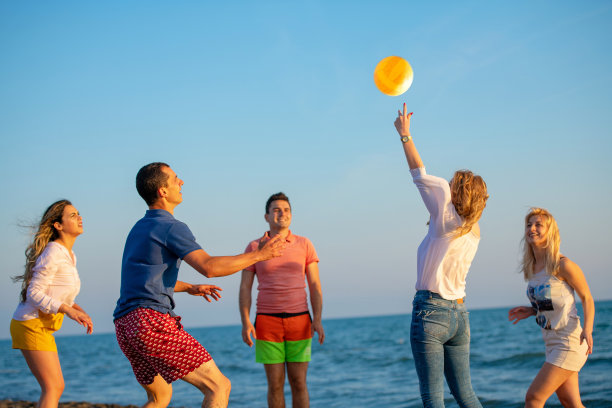 一群年轻人在沙滩上打排球图片下载