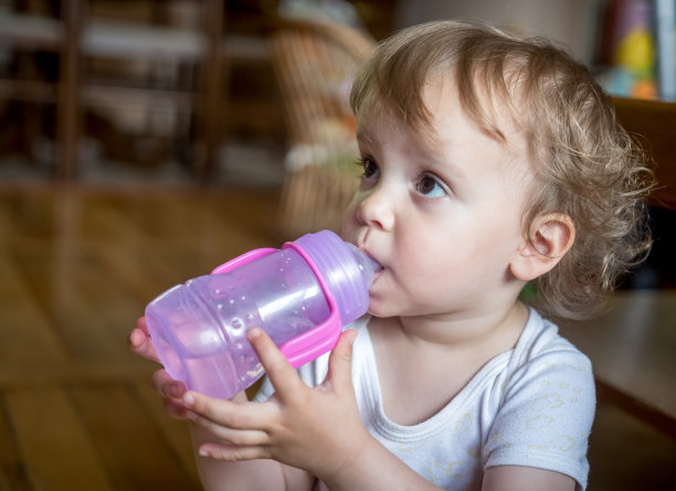 可爱的孩子从瓶子里喝水图片下载