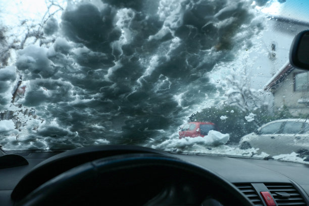 冬天的车结冰了，挡风玻璃上覆盖着雪花。冬季运输概念图片下载