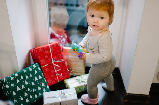 一个小女孩的肖像在节日礼物的房间附近。节日生日的概念。照片里的快乐宝宝。婴儿。3月8日是国际妇女节。圣诞快乐，节日快乐。图片下载