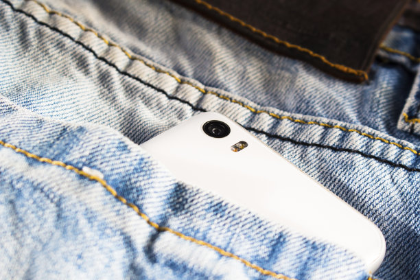 蓝色牛仔裤里藏着白色智能手机图片下载
