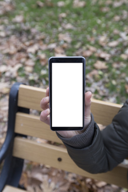 女人手握白色智能手机，黑屏在小角度的位置图片下载