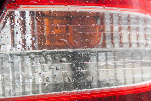 现代汽车的后头灯近视图与水滴上。红色和白色。布局的装饰和设计在交通。洗车或下雨后的汽车细节。汽车外部的部分。图片下载