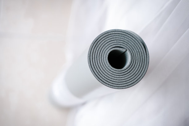 粉彩卷瑜伽垫在白色的背景图片下载