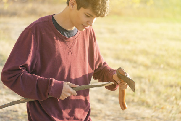 男旅行者在登山前用斧头把木棍砍断图片下载