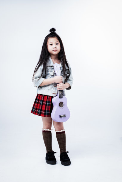 小女孩手里拿着四弦琴，带着微笑和幸福的感觉图片下载