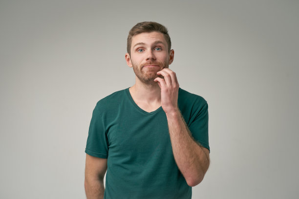 照片中严肃的男人抱着下巴，陷入沉思，想办法解决问题。姜男在工作室室内摆姿势图片下载