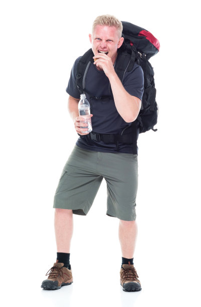 迷人的年轻男性徒步旅行者吃和喝零食图片下载