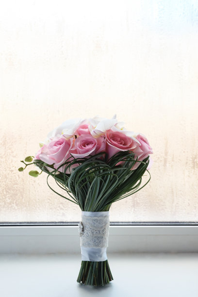 窗台上用白玫瑰和百合做成的婚礼花束图片下载