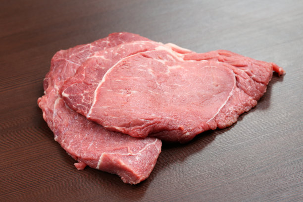 桌上有新鲜的牛排。桌子上的生牛肉块。图片下载