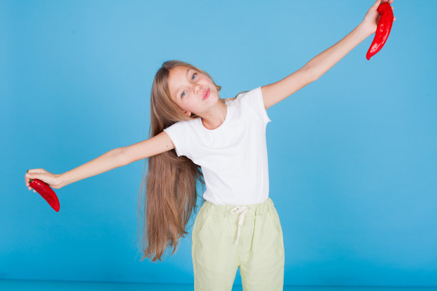 一个漂亮女孩的肖像用红辣椒新鲜的蔬菜图片下载