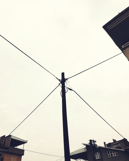 房屋之间的电塔和电缆图片下载