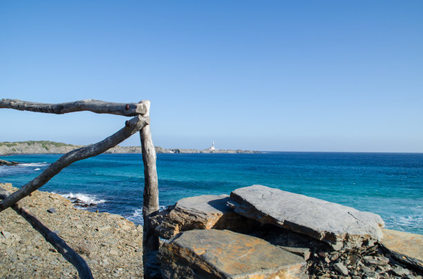灯塔远高于岩石公路面朝大海的风景照片图片下载