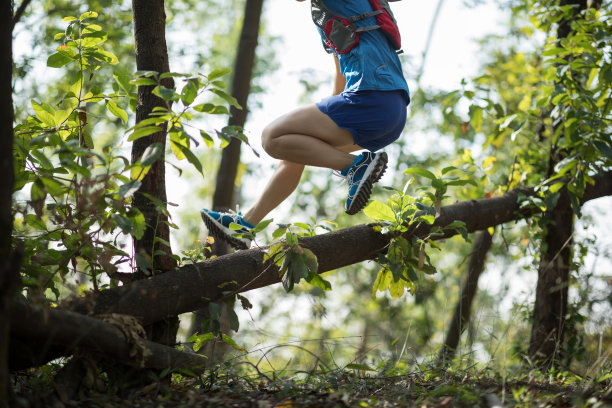 女运动员在森林里穿越乡间小道图片下载