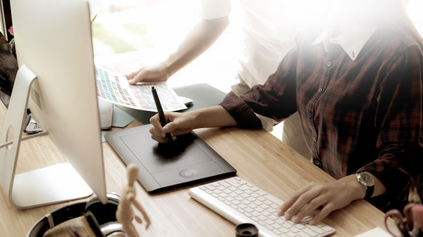 年轻的女设计师在工作室的数字图形绘图板上画草图。图片下载