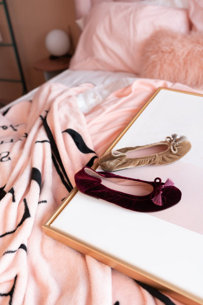 彩色的鞋子设置在金色框架与折皱的粉色毯子下面/舒适的室内概念/时尚照片与创意的背景图片下载