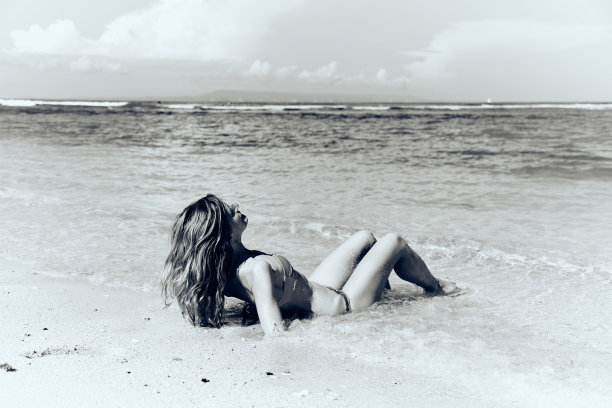 苗条的女人享受在一个热带沙滩上。图片下载