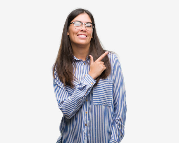 年轻美丽的西班牙女商人愉快的微笑的脸指向与手和手指向上到一边与快乐和自然的表情在脸上看着相机。图片下载