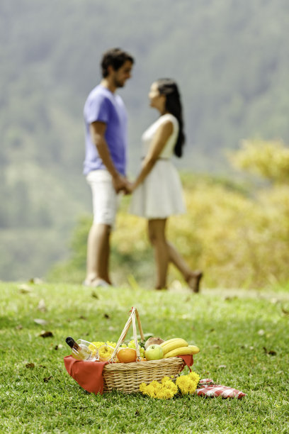 轻松和热爱拉丁幸福夫妇享受野餐在公园图片下载