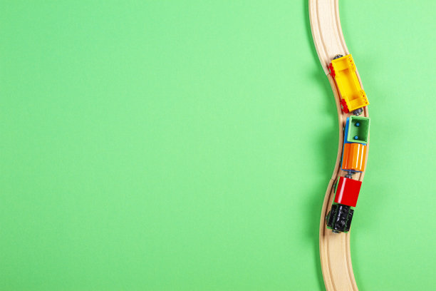 绿色背景上的玩具火车和木制栏杆图片下载