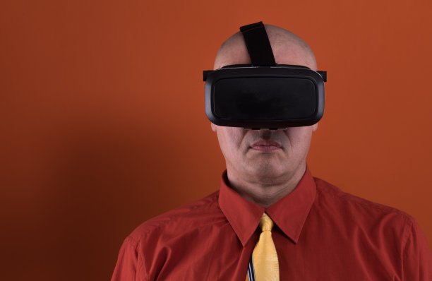 男人戴上现代VR眼镜在智能手机上玩虚拟现实手机游戏图片下载