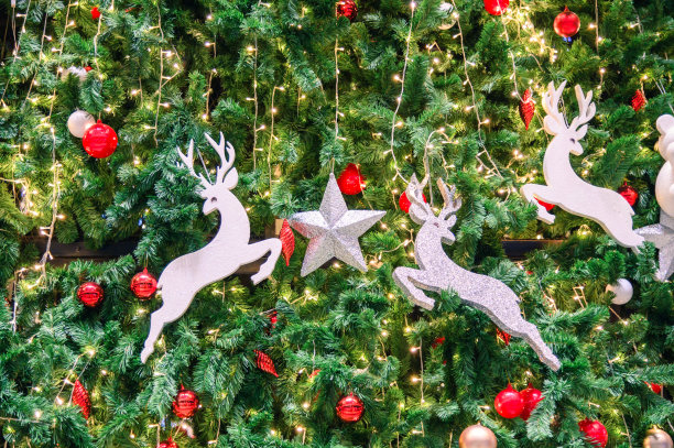 用鹿玩具、红球、星星和灯泡装饰圣诞树图片下载