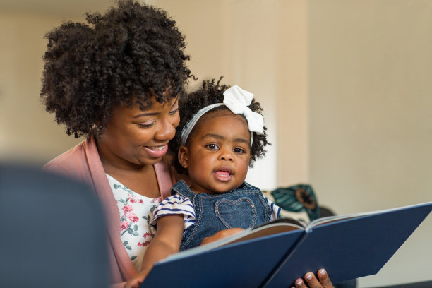 妈妈在给她的小女儿读书。图片下载